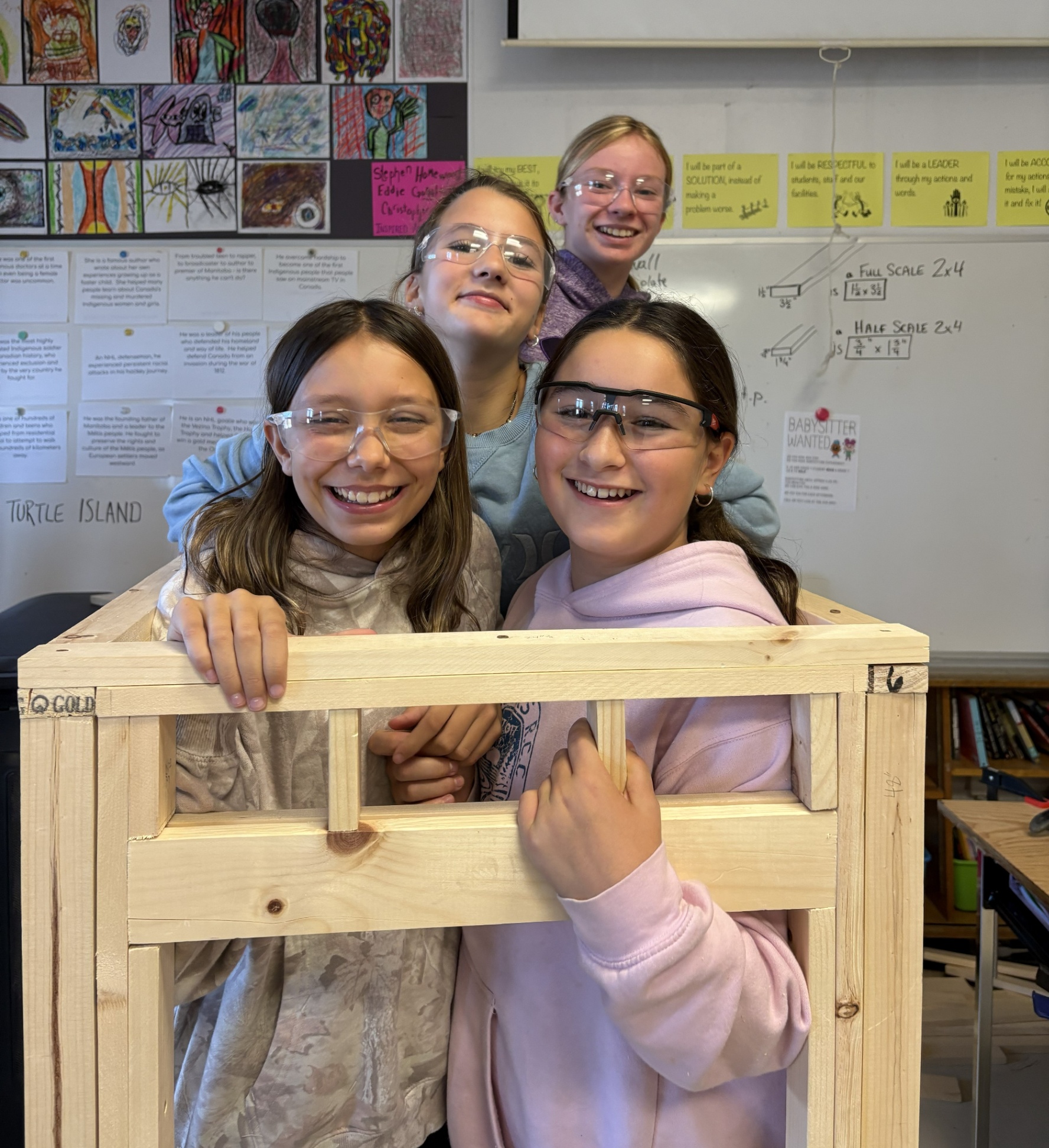 Four Elginburg carpentry students stand inside of the structure they built