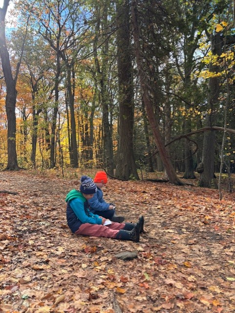 Students sitting on the ground at Lemoine Point in autumn 2025